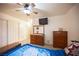 This bedroom features a ceiling fan, a dresser with mirror, and a mounted television at 4616 E Idaho Ave, Las Vegas, NV 89104