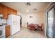 Eat-in kitchen features wood cabinets, white appliances, and a sliding glass door leading to the backyard at 4616 E Idaho Ave, Las Vegas, NV 89104