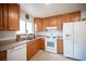 Well-lit kitchen featuring wood cabinets, white appliances, and tile flooring at 4616 E Idaho Ave, Las Vegas, NV 89104