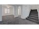Living room featuring gray carpet, stairs, ceiling fan and an open floor plan at 4751 Lone Grove Dr, Las Vegas, NV 89139