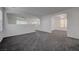 Bright living room with neutral walls, plush gray carpet and a ceiling fan at 4751 Lone Grove Dr, Las Vegas, NV 89139