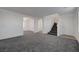 Bright, open-concept living room with neutral gray carpeting, stairway and a ceiling fan at 4751 Lone Grove Dr, Las Vegas, NV 89139