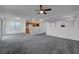 Open-concept living room features plush carpeting, view of kitchen and sliding glass door at 4751 Lone Grove Dr, Las Vegas, NV 89139