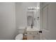 A white half bath featuring a toilet, sink, and door at 483 Marina Cv, Boulder City, NV 89005