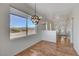 Cozy dining area with hardwood floors, modern lighting fixture, and large windows offering stunning mountain views at 483 Marina Cv, Boulder City, NV 89005