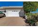 A well maintained garage area with a manicured lawn with desert foliage at 483 Marina Cv, Boulder City, NV 89005