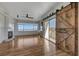 Spacious living room with wood floors, fireplace, and sliding barn door to a balcony at 483 Marina Cv, Boulder City, NV 89005