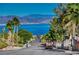 Scenic street view with palm trees and a glimpse of the lake and mountains in the distance at 483 Marina Cv, Boulder City, NV 89005