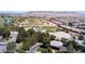 An aerial view of a community, golf course with pond, and a clubhouse surrounded by lush trees at 5918 Terra Grande Ave, Las Vegas, NV 89122