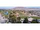 An aerial view of a golf course community, showcasing lush green fairways, a blue pond, and clubhouse at 5918 Terra Grande Ave, Las Vegas, NV 89122