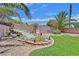 Scenic backyard with a rock waterfall feature and synthetic lawn at 5918 Terra Grande Ave, Las Vegas, NV 89122