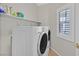 Bright laundry room featuring a front-load washer and dryer set and shelves at 5918 Terra Grande Ave, Las Vegas, NV 89122