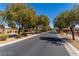 A street view of the community entry featuring a gated entrance, landscaping and mature shade trees at 5918 Terra Grande Ave, Las Vegas, NV 89122