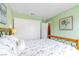 Bright bedroom with light green walls, plush pillows, and wood laminate flooring for a cozy feel at 6536 Pleasant Plains Way, Las Vegas, NV 89108