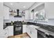 Updated kitchen featuring white cabinets, black countertops, and stainless steel appliances at 6536 Pleasant Plains Way, Las Vegas, NV 89108