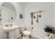 Clean half bathroom with a pedestal sink, toilet, and decorative wall art at 709 Pickled Pepper Pl, Henderson, NV 89011