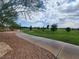 The walking path travels through a park, lined with mature trees and lush landscaping at 709 Pickled Pepper Pl, Henderson, NV 89011