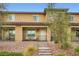 Inviting two-story townhouse featuring a stone accent, landscaped front yard, and covered porch, perfect for relaxing outdoors at 709 Pickled Pepper Pl, Henderson, NV 89011