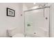 Enclosed shower with glass door, toilet, and shelving unit for toiletries at 709 Pickled Pepper Pl, Henderson, NV 89011
