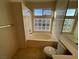 Bright bathroom featuring a soaking tub with decorative glass block window and ceramic tile at 8704 Autumn Wreath Ave, Las Vegas, NV 89129
