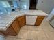 Kitchen island with tiled countertop and sink, plus wooden cabinets and white dishwasher at 8704 Autumn Wreath Ave, Las Vegas, NV 89129