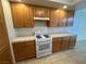 Kitchen features wooden cabinets, white tile countertops, and white gas range at 8704 Autumn Wreath Ave, Las Vegas, NV 89129
