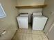 Efficient laundry area with a white washer and dryer set, and tile floors at 8704 Autumn Wreath Ave, Las Vegas, NV 89129