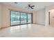 Open living area with tile flooring, ceiling fan, and large sliding doors to the outdoor patio at 8732 Kendall Brook Cir, Las Vegas, NV 89149