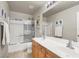 Bathroom with a double sink vanity, tiled floor, tub and shower with glass door at 9408 Ironsend St, Las Vegas, NV 89143