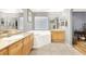 Bathroom featuring double vanities, soaking tub, tile floor, and modern lighting at 9408 Ironsend St, Las Vegas, NV 89143