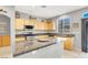 Well-lit kitchen features wooden cabinets, granite countertops, and modern stainless steel appliances at 9408 Ironsend St, Las Vegas, NV 89143