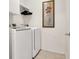 Bright laundry room with white washer and dryer, plus storage and a decorative wall hanging at 9408 Ironsend St, Las Vegas, NV 89143