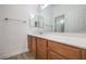 Bathroom featuring wooden cabinets, light countertop and dual mirrors at 9421 Wisdom Valley Ave, Las Vegas, NV 89149