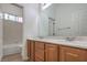 Bathroom featuring a toilet, tiled shower over tub, vanity and dual mirrors at 9421 Wisdom Valley Ave, Las Vegas, NV 89149