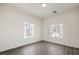 Bright bedroom featuring two windows and gray wood-look flooring at 9421 Wisdom Valley Ave, Las Vegas, NV 89149