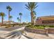 Gated community entrance with well-maintained landscaping and mature palm trees at 9421 Wisdom Valley Ave, Las Vegas, NV 89149