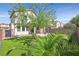 Beautifully landscaped backyard with artificial turf, mature landscaping, and views of the home at 953 Via Del Tramonto St, Henderson, NV 89011