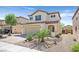 Two-story home featuring a two-car garage, desert landscaping, and a charming front porch at 953 Via Del Tramonto St, Henderson, NV 89011