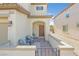 Inviting front porch with seating area, brick pavers, and an arched entryway to the home at 953 Via Del Tramonto St, Henderson, NV 89011