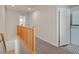 Upstairs hallway featuring neutral tones, a wood railing, and a laundry closet at 953 Via Del Tramonto St, Henderson, NV 89011