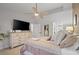 Bright main bedroom featuring a ceiling fan, large dresser, soft carpet, and a walk in closet at 9540 Eagle Valley Dr, Las Vegas, NV 89134