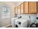 Functional laundry room with light wood cabinets, washer, and dryer at , Las Vegas, NV 89149