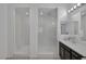 Bright bathroom featuring sleek white counters, dark cabinets, tile floor, and walk-in glass enclosed showers at 10181 Mount Harlow Ct, Las Vegas, NV 89141