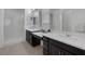 Bright bathroom featuring double sinks with dark cabinets, sleek white counters, and a glass-enclosed shower at 10181 Mount Harlow Ct, Las Vegas, NV 89141