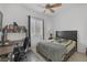 This bedroom features a bed, desk, bookshelf, window with shutters, and ceiling fan at 10181 Mount Harlow Ct, Las Vegas, NV 89141