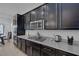 Stylish kitchen showcasing dark cabinets, stainless steel appliances, and sleek granite countertops at 10181 Mount Harlow Ct, Las Vegas, NV 89141