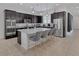 Spacious kitchen featuring dark cabinets, stainless steel appliances, and a large center island with seating at 10181 Mount Harlow Ct, Las Vegas, NV 89141