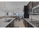 Open concept kitchen with stainless steel appliances, dark cabinets, and seamless flow to dining and living areas at 10181 Mount Harlow Ct, Las Vegas, NV 89141