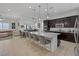 Open-concept kitchen with a large island, modern lighting, and views of the living and dining areas at 10181 Mount Harlow Ct, Las Vegas, NV 89141