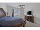This main bedroom features a ceiling fan, carpeted floor, TV on dresser, and a window with blinds and curtains at 10181 Mount Harlow Ct, Las Vegas, NV 89141